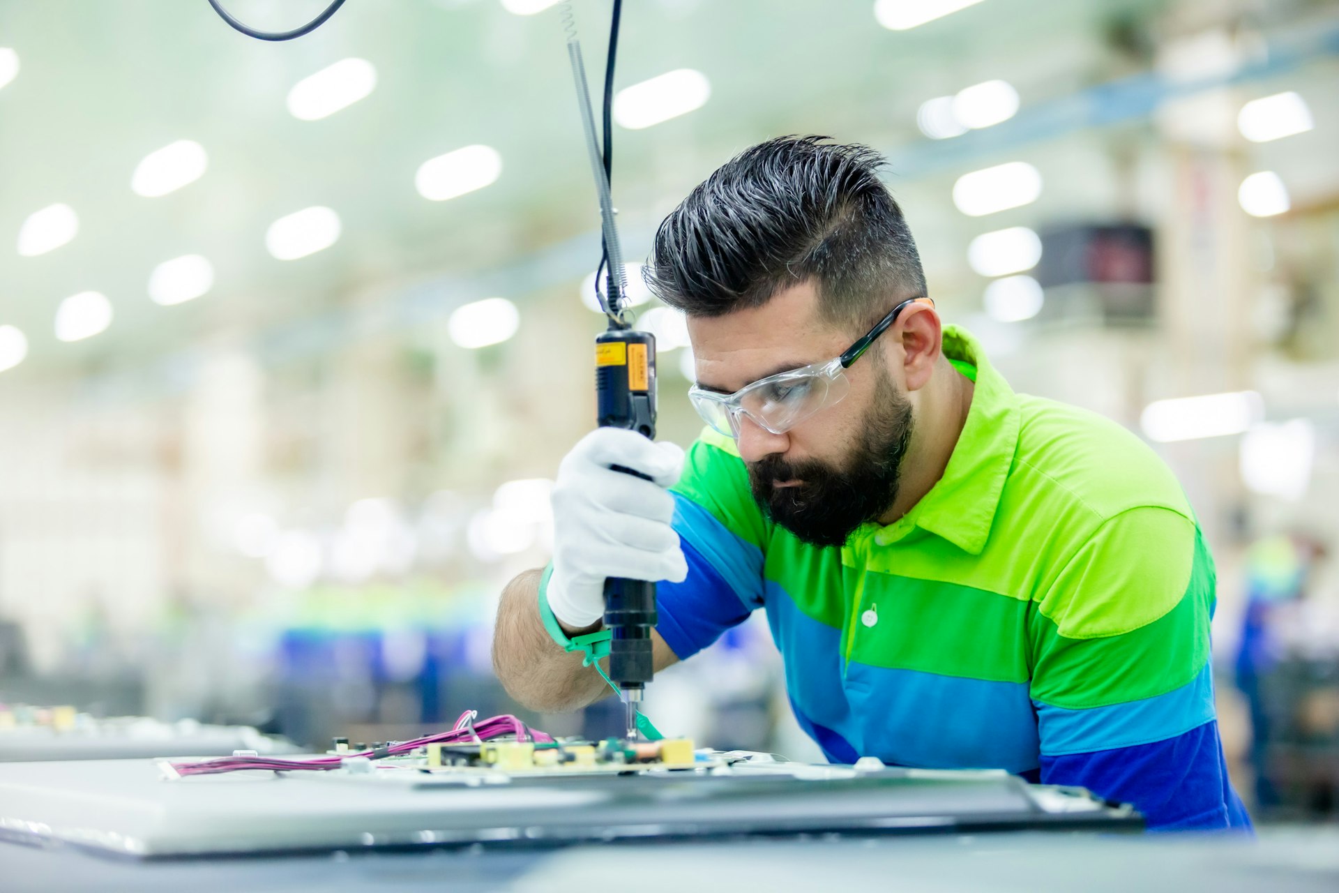 A machinist working on a piece of equipment on a manufacturing floor